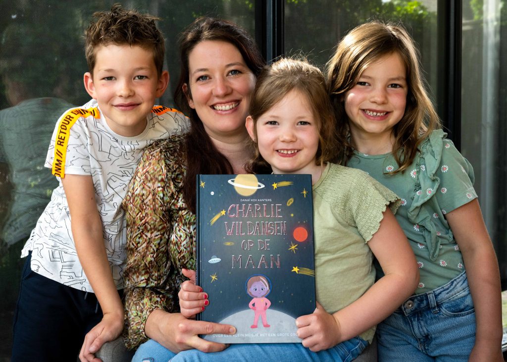 Danai met kinderen die het boek 'Charlie wil dansen op de maan' vast hebben.